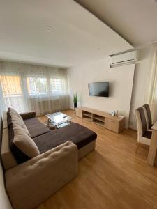 a living room with a couch and a flat screen tv at Apartman Atos stan na dan in Prijedor