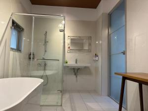 a bathroom with a shower and a sink and a tub at 上水民宿 in Chiayi City