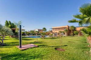 un patio con piscina, palmeras y un edificio en leila farmhouse en Marrakech