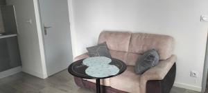 ein braunes Sofa mit zwei Kissen und einem Tisch in der Unterkunft Appartement 2 pièces in Rive-de-Gier