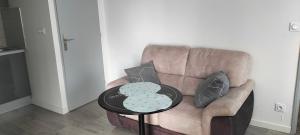 a brown couch with two pillows and a table at Appartement 2 pièces in Rive-de-Gier +2 photos