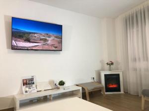 a living room with a fireplace and a tv on the wall at Centrico alojamiento in Jaén