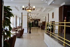 Al-faleh Hotel في الباحة: لوبي فيه كراسي وطاولات في مبنى