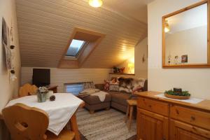 ein Wohnzimmer mit einem Sofa und einem Tisch in der Unterkunft Pension Marianne in Inzell