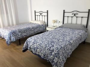 1 dormitorio con 2 camas y edredón azul y blanco en Centrico alojamiento, en Jaén