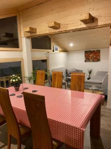 uma sala de jantar com uma mesa vermelha e cadeiras em Chalet Bärgstäger em Lauterbrunnen