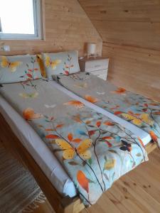 a bed with a blanket with butterflies on it at Rudnička čarolija in Rudnik Kačerski