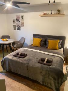 ein Schlafzimmer mit einem Bett mit gelben Kissen und einem Tisch in der Unterkunft Gemütliches Apartment Nähe Weinheim HD MA, Work and Travel in Birkenau