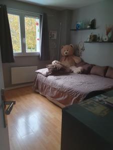 een teddybeer op een bed in een slaapkamer bij Room in BB - Nathalies home - 2 Bedrooms Breakfast in Viry-Châtillon