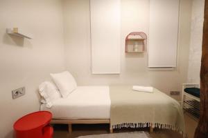 ein weißes Schlafzimmer mit einem Bett und einem roten Stuhl in der Unterkunft Prime Location Modern Stay in San Sebastián