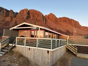 a house in the desert with a mountain in the background at Mulakot Cosy Cabins in Borgarnes