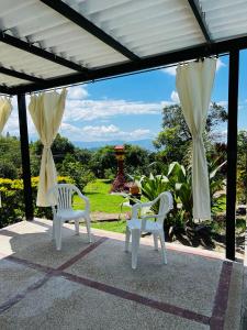 dwa białe krzesła i stół na patio w obiekcie casa campestre w mieście Fusagasugá