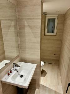 uma casa de banho com um lavatório e um espelho em Venis Hotel em Tirana