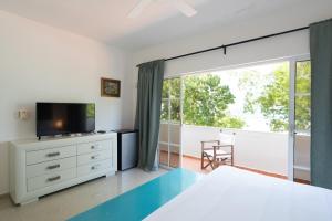 a bedroom with a bed and a large window at Blue Island Punta Rucia in Punta Rucia