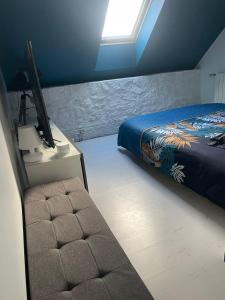 Saint-Pierre-Aigle的住宿－Maison Vue Panoramique，一间卧室配有一张床和一张桌子上的电视
