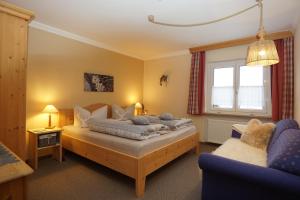 um quarto com uma cama e um sofá em Pension Marianne em Inzell
