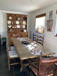 a dining room with a wooden table and chairs at Rhedyn - Cosy Fishing Lodge Near Aberaeron in Cross Inn