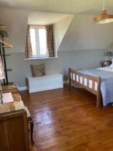 a bedroom with a bed and a wooden floor at Rhedyn - Cosy Fishing Lodge Near Aberaeron in Cross Inn