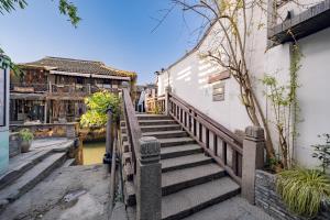 una escalera de madera que conduce a un edificio con un edificio en Ancient Residence Riverview B&B 300year old en Shanghái