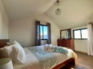 a bedroom with a bed with two towels on it at Pink House in Ponta do Sol