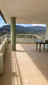 a balcony with a table and a view of mountains at Apartamento de lujo mar y montaña para todo el año con calefacción spa gimnasio y piscina climatizada in Tavernes de Valldigna