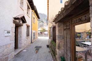 an alley in an old town with a table and a building at Casa Rural Los Arrieros in La Puerta
