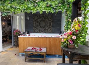 a bath tub in a garden with flowers on a table at Apartamento Noche Romántica in Bogotá