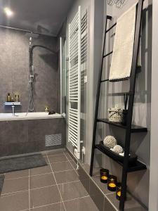 L'Entre 2 - Suite de charme avec sauna et baignoire balnéo في Amay: حمام به سلم اسود وحوض استحمام