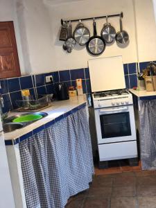 cocina con fogones y fregadero con ollas y sartenes en Casa Esperanza en Lanjarón