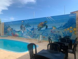 a mural of a swimming pool in a restaurant at Happy Hostel e Pousada Paracuru in Paracuru