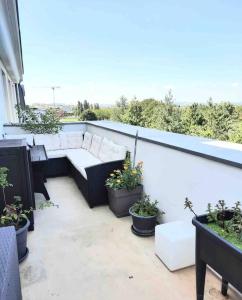 a balcony with a couch and some potted plants at Très Bel appart proche CDG Bourget et Paris in Le Blanc-Mesnil