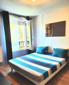 a bedroom with a large bed with blue pillows at Très Bel appart proche CDG Bourget et Paris in Le Blanc-Mesnil