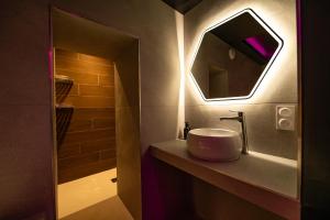 クレルモン・フェランにあるLV Suites Jaudeの洗面台と鏡のあるバスルーム +3枚の写真