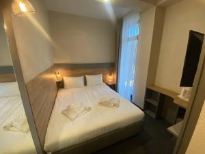 um quarto com uma cama branca e uma janela em HOTEL ARTA em Starychi