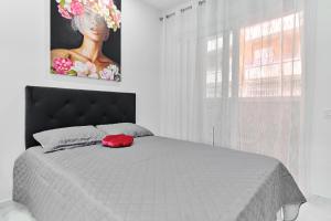 a bedroom with a bed with a red hat on it at Centro Modern Beach & Spa in Torrevieja