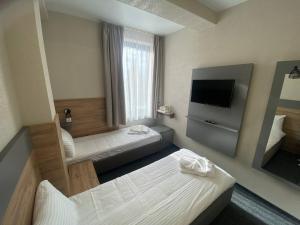 um quarto de hotel com duas camas e uma televisão de ecrã plano em HOTEL ARTA em Starychi
