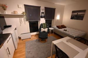una pequeña sala de estar con sofá y mesa. en One-room dorm with kitchenette, bath, bed 140x200, en Stavanger