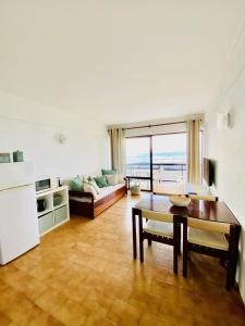 a living room with a table and a couch at Caparica Sea View Apartment in Costa da Caparica