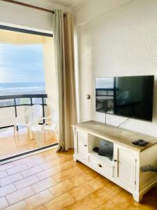 a living room with a flat screen tv on a wall at Caparica Sea View Apartment in Costa da Caparica