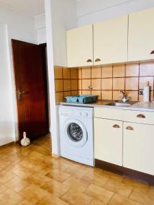 a kitchen with a washing machine and a sink at Caparica Sea View Apartment in Costa da Caparica