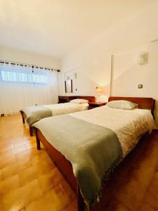 a bedroom with three beds in a room at Caparica Sea View Apartment in Costa da Caparica +34 photos