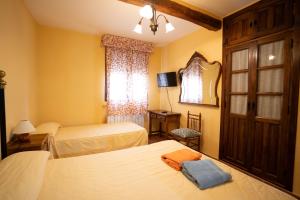 a hotel room with two beds and a mirror at Casa Rural Los Arrieros in La Puerta