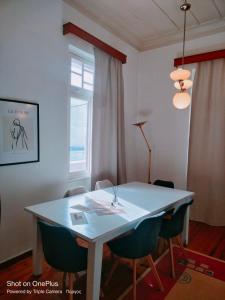 una sala da pranzo con tavolo e sedie bianchi di Pyrgos City 3bedrooms house near Olympia sleeps 7 a Pýrgos