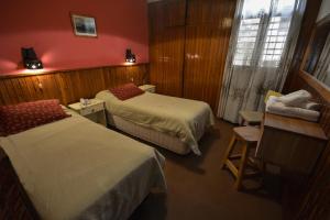 Habitación de hotel con 2 camas y ventana en Hostería Sur en San Carlos de Bariloche