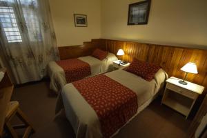 a hotel room with two beds and two lamps at Hostería Sur in San Carlos de Bariloche +8 photos