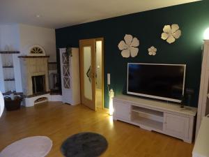 a living room with a flat screen tv on a wall at BlueteNo1 mit Sauna, Kamin und Garten in Wiesmoor