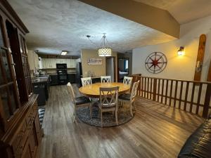 cocina y comedor con mesa y sillas en Lakeside Getaway with Hot Tub, en Gaylord