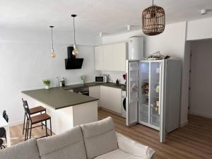 a kitchen and living room with a couch and a refrigerator at 5 rooms 3 minutes from the beach in Almería
