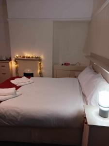 a bedroom with a large white bed and a mirror at Amarillys Guest House in Preston