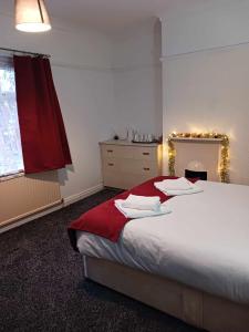 a bedroom with a large bed with a red blanket at Amarillys Guest House in Preston